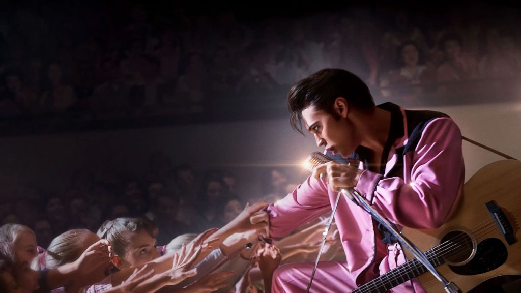 Austin Butler dans le rôle d’Elvis Presley en concert, en costume rose, au contact du public dans le film Elvis