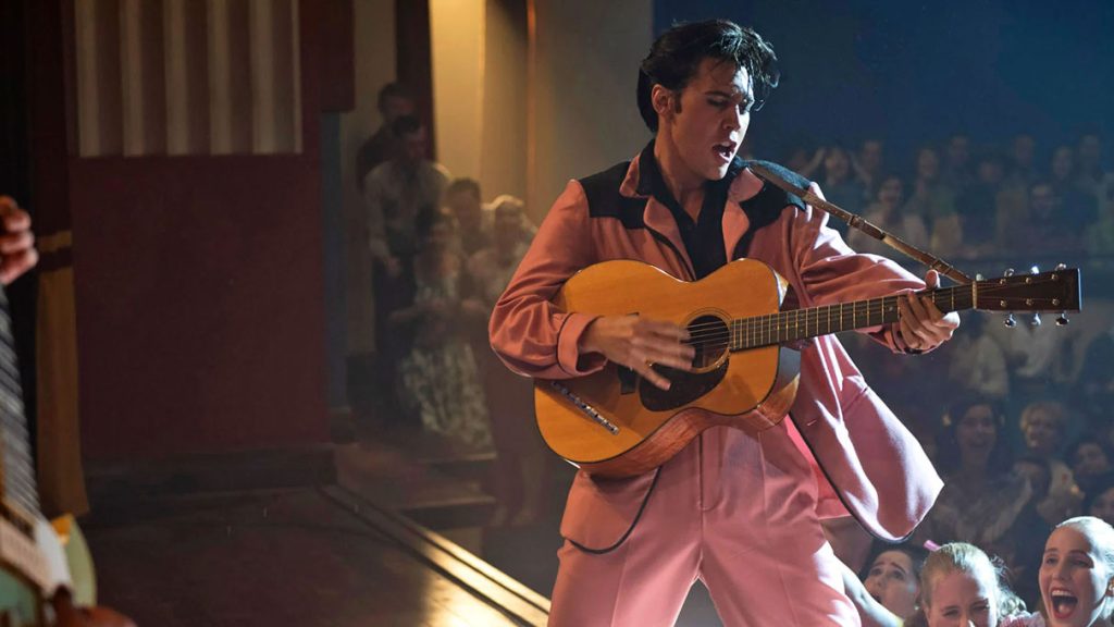 Austin Butler interprétant Elvis Presley sur scène avec une guitare dans le film Elvis de Baz Luhrmann