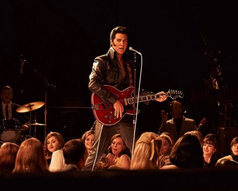 Austin Butler dans le rôle d’Elvis Presley sur scène avec une guitare rouge dans le film Elvis