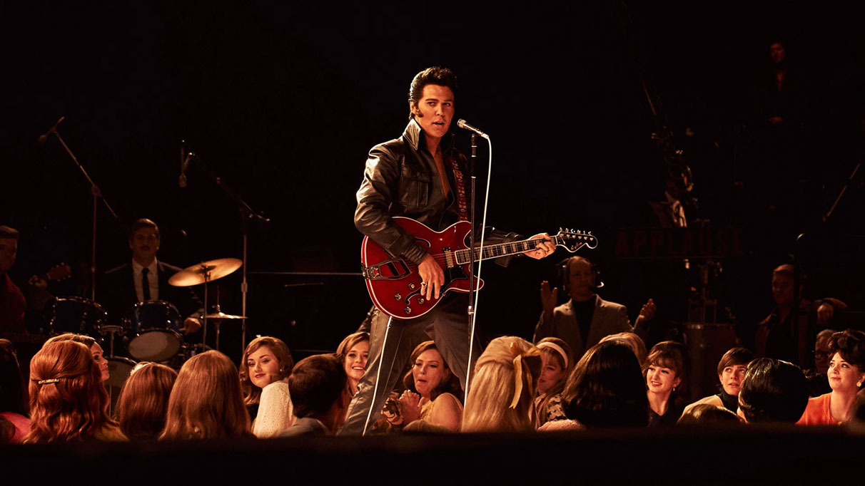 Austin Butler dans le rôle d’Elvis Presley sur scène avec une guitare rouge dans le film Elvis