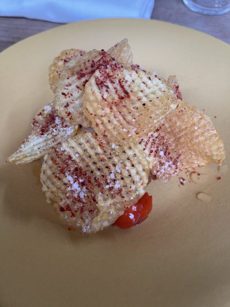 Amuse-bouche croustillant, tuile fine et piment rouge, servi au restaurant Le Servan à Paris.