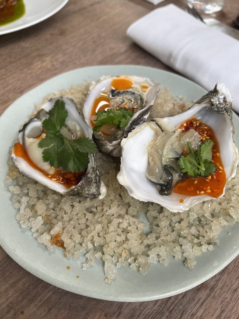 Huîtres servies sur glace pilée, sauce pimentée, sésame et coriandre au restaurant Le Servan à Paris.