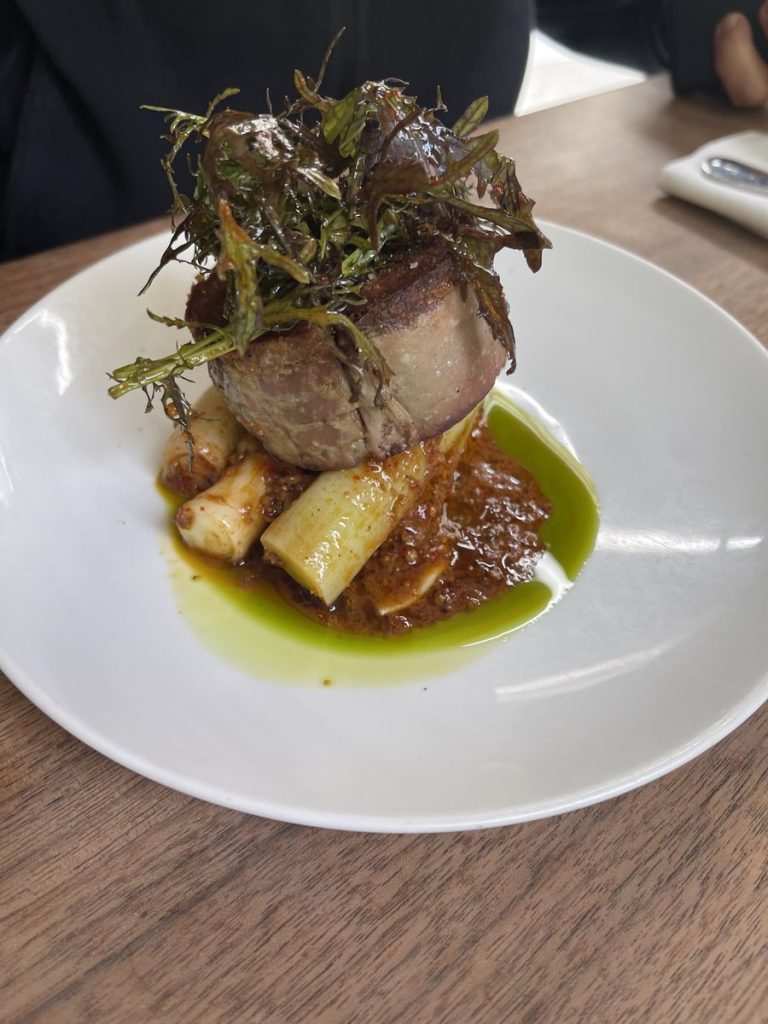 Pièce de viande rôtie avec poireaux, herbes et sauce pimentée au restaurant Le Servan à Paris.