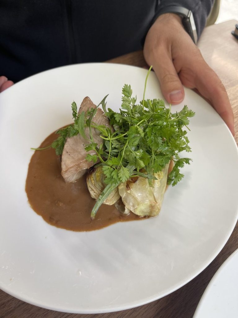 Assiette de veau avec artichauts, herbes fraîches et sauce au restaurant Le Servan à Paris.