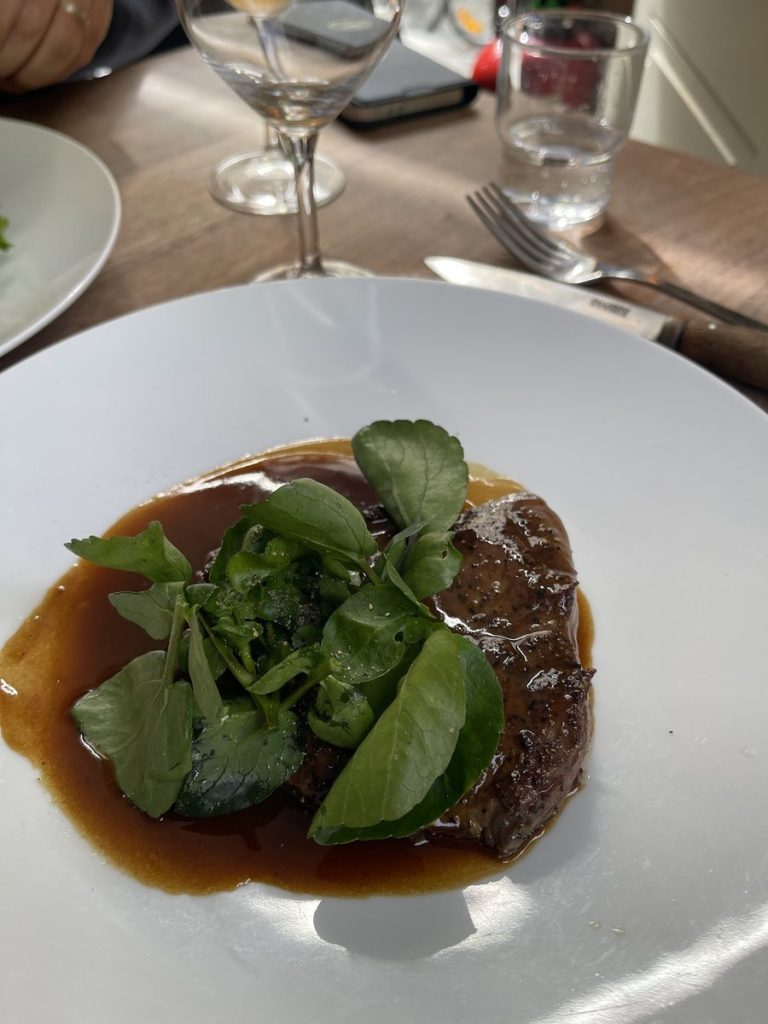 Plat de viande nappé de jus brun avec cresson frais au restaurant Le Servan à Paris.