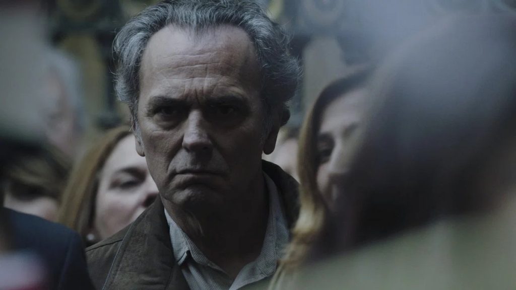 José Coronado dans Tu hijo, visage fermé au milieu d’une foule