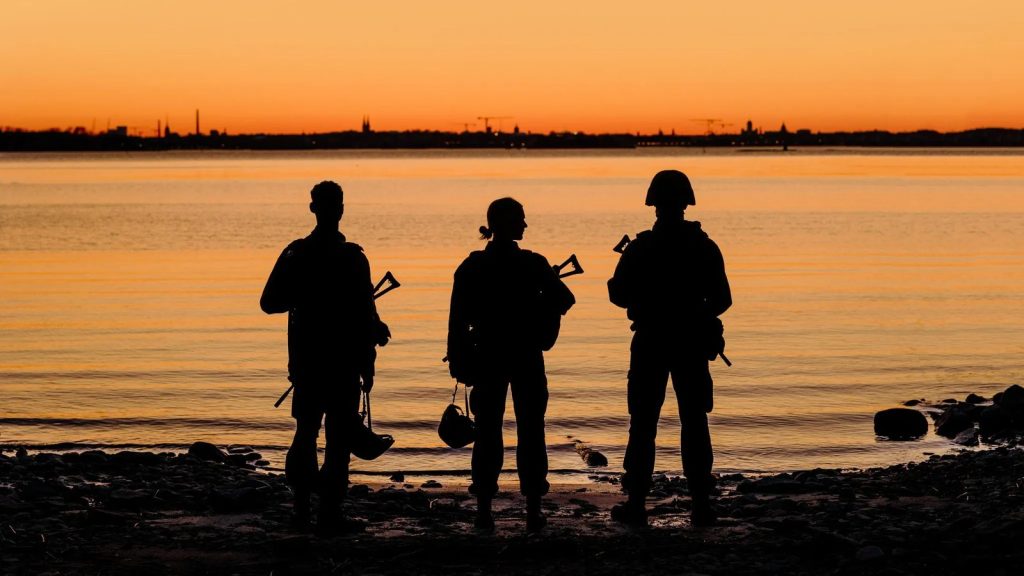 Conflict série finlandaise, soldats armés en silhouette face à la mer au crépuscule