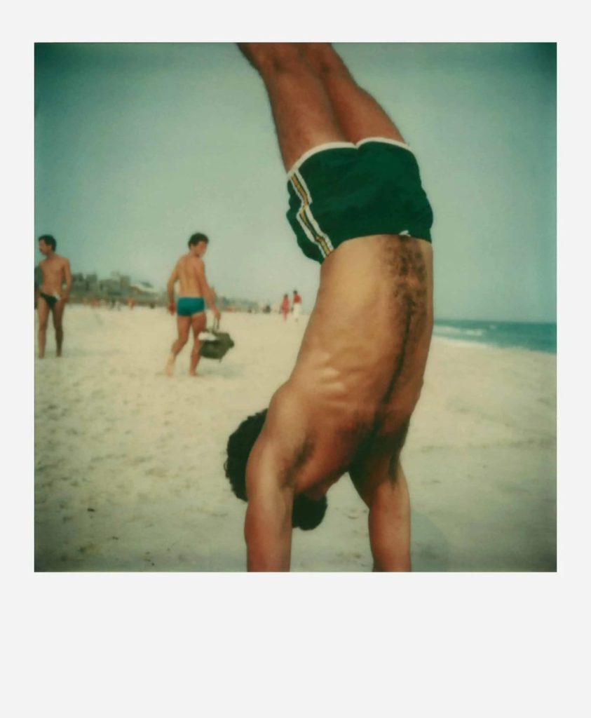 Homme en équilibre sur les mains sur la plage de Fire Island Pines, photographie de Tom Bianchi illustrant le thème de l'émancipation homosexuelle dans l'exposition Fragile Beauté au Jeu de Paume