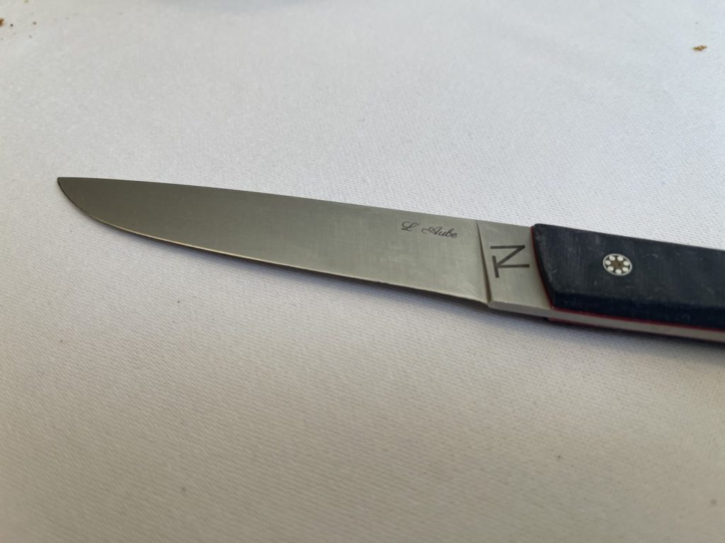 Le couteau gravé "L'Aube" du restaurant Panurge, posé sur la nappe.